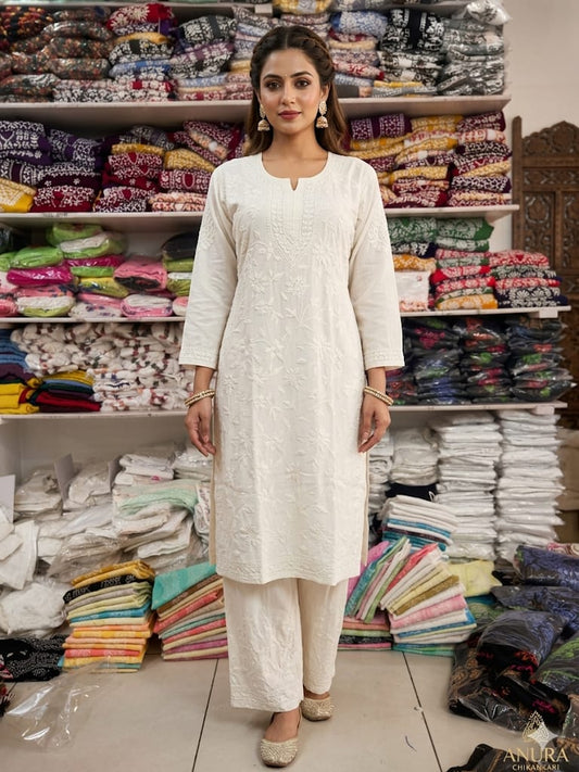 Woman in a white outfit standing in front of shelves stocked with fabric in a store.
